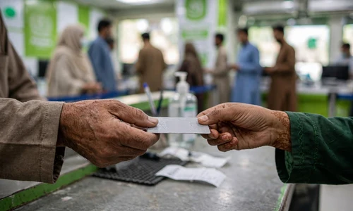 Hands exchanging an identity document at a government registration counter